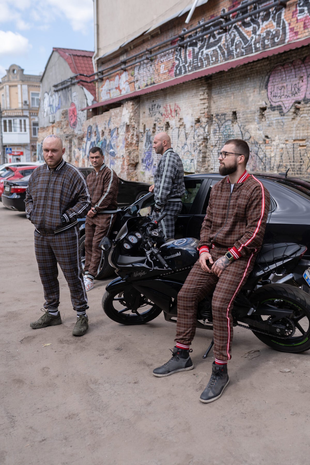 Premium Coffee Checkered Gentlemen Tracksuit — group photo with a motorcycle