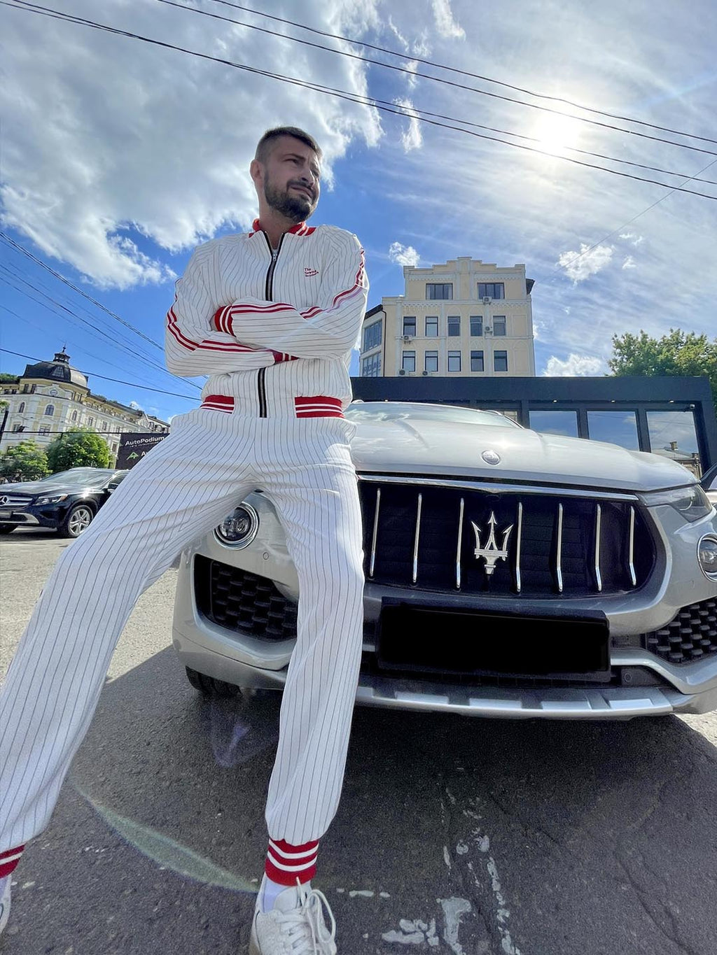 Premium White & Red Pinstripe Gentlemen Tracksuit — standing next to a car