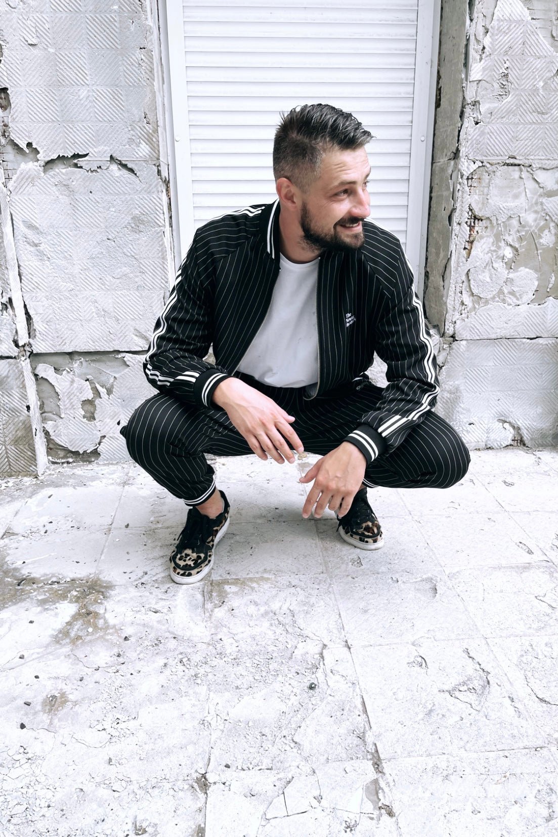Premium Black Pinstripe Gangster Gentlemen Tracksuit — crouching pose