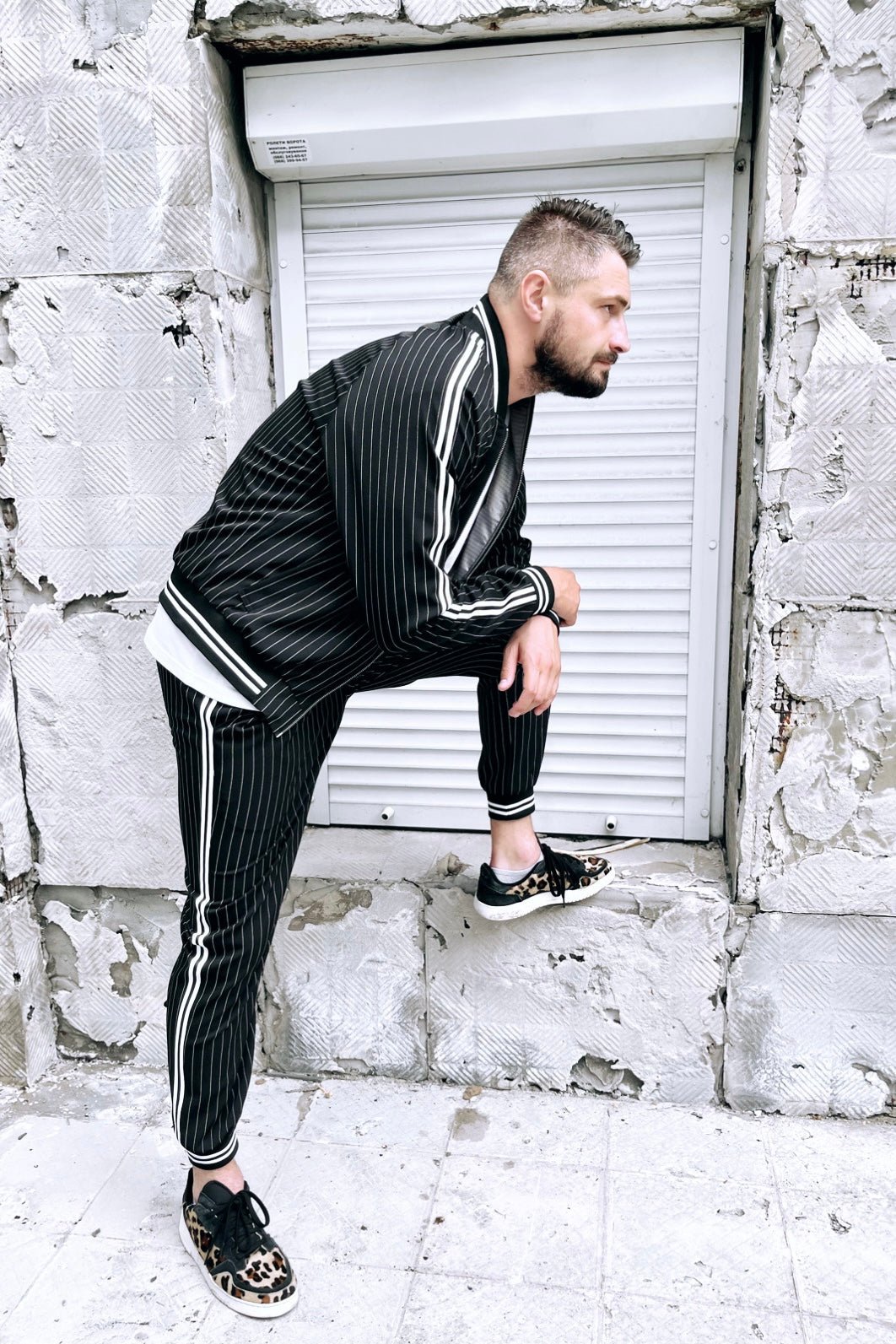 Premium Black Pinstripe Gangster Gentlemen Tracksuit — posed with one foot raised