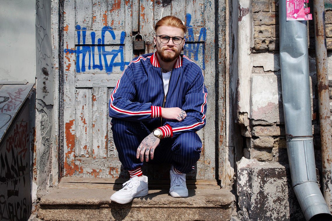 Premium Navy Blue Pinstripe Gentlemen Tracksuit — crouching pose