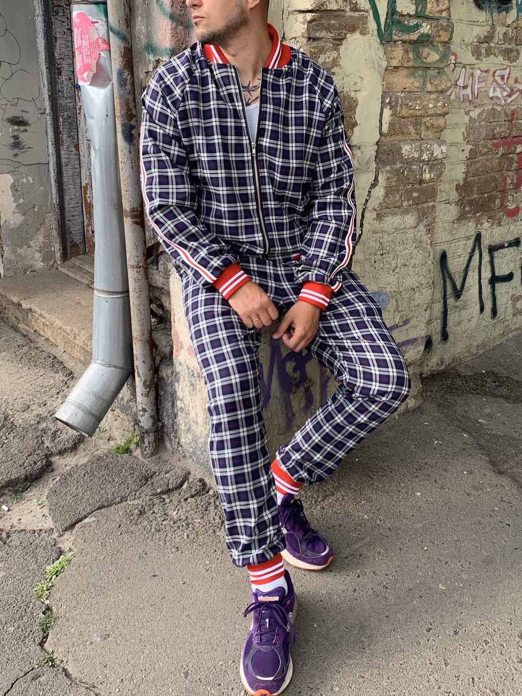 Premium Navy Check Gentlemen Tracksuit — check bomber jacket and joggers, leaning against a wall