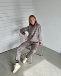 Women's Mauve Glen Plaid Tracksuit — glen plaid bomber jacket and joggers inspired by The Gentlemen, seated pose